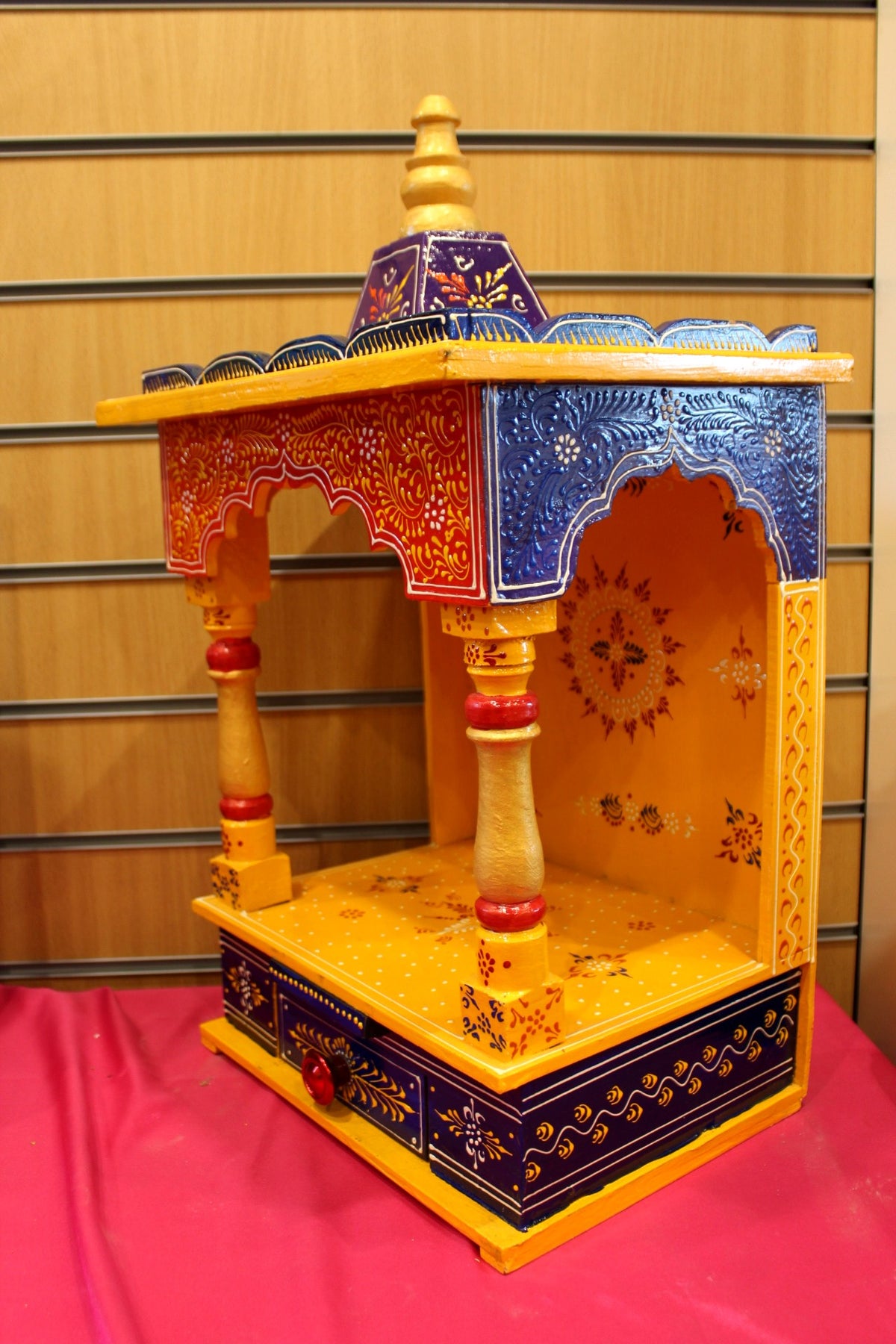 Close view of the marigold mandir open niche, turned pillars and base drawer