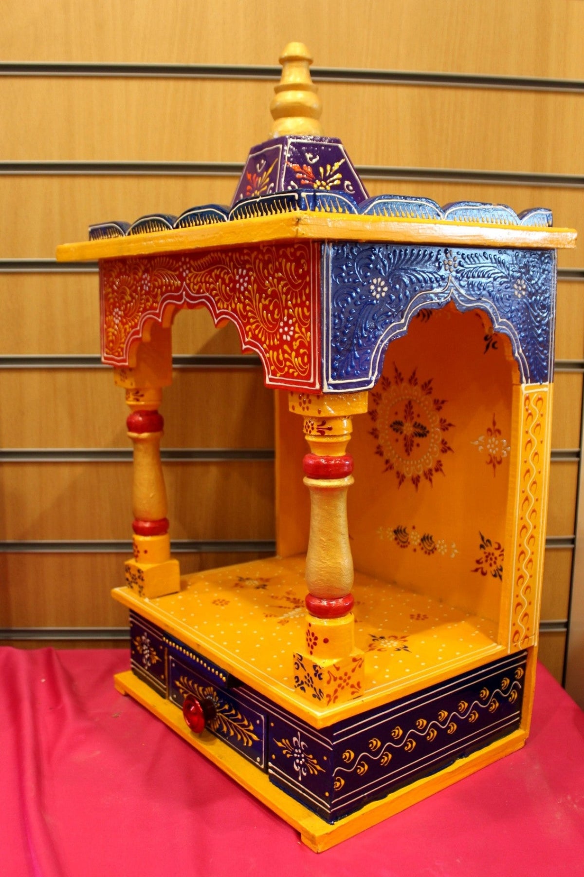 Close view of the marigold mandir open niche, turned pillars and base drawer
