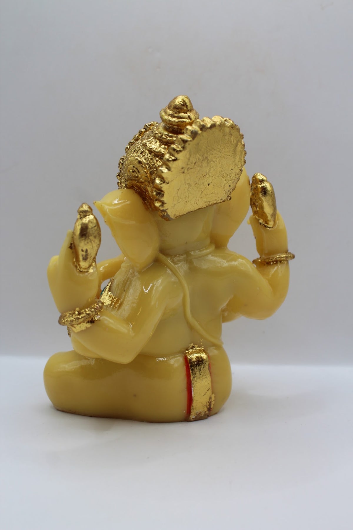 Cream resin Ganesh murti seated, gold crown, back view