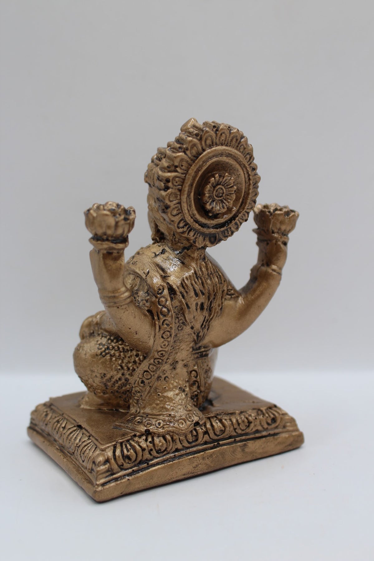 Antique gold resin Laxmi murti seated on square base, back view