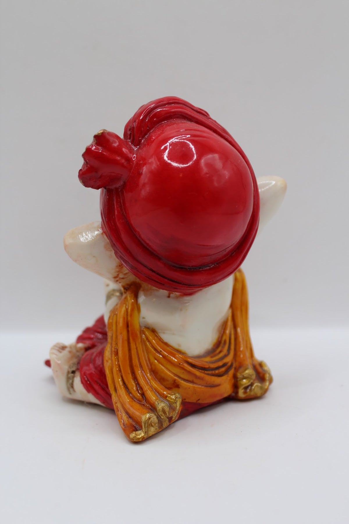 Baby Ganesh murti in red turban, blessing hand, back view