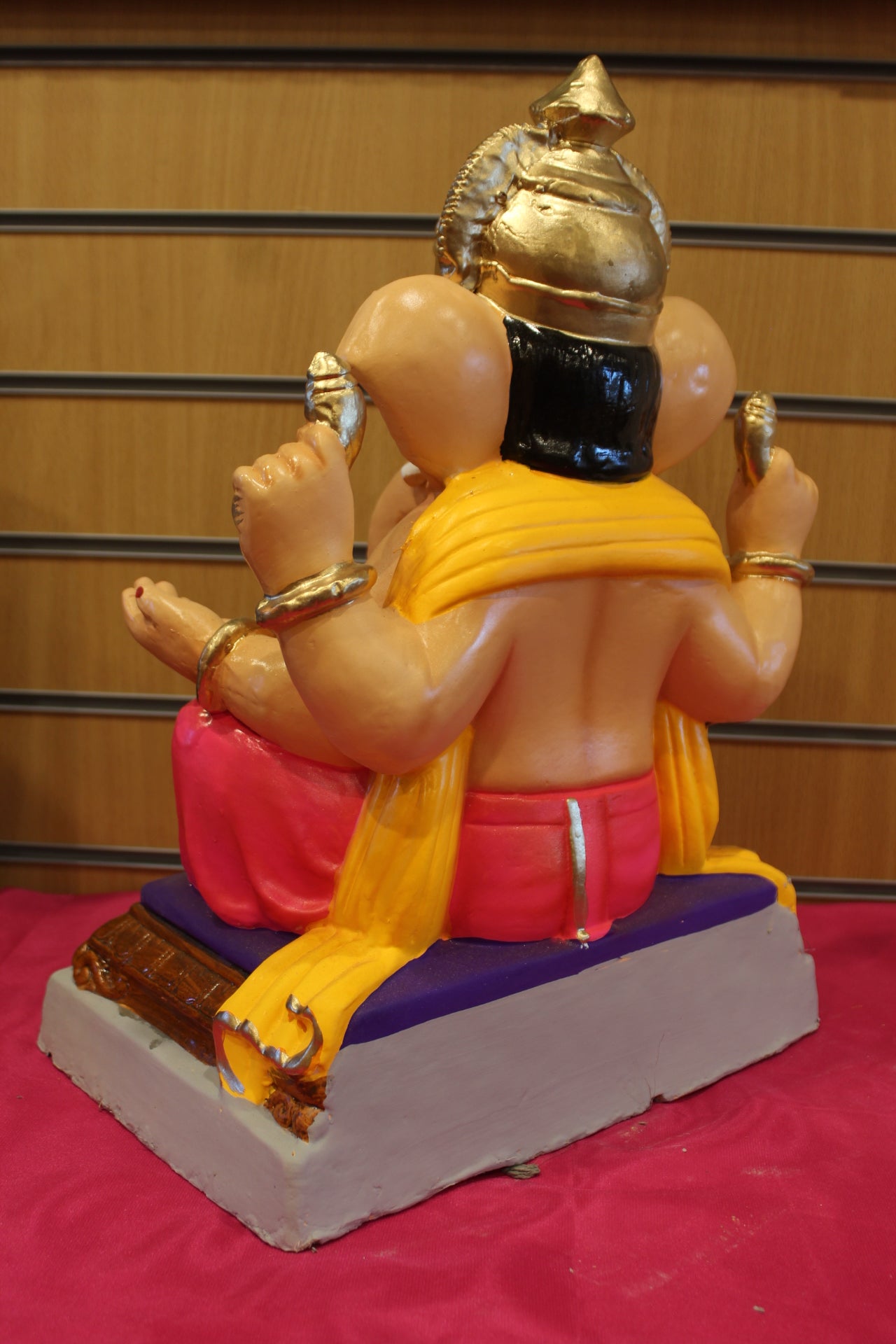 Back view – saffron khes and rani pink dhoti on carved chowki