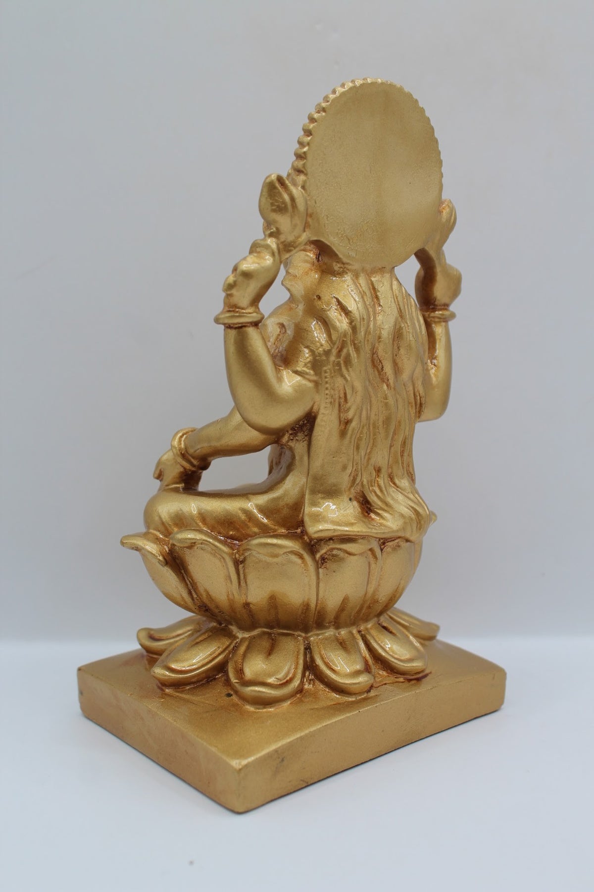 Gold resin Laxmi murti seated on a lotus, back view