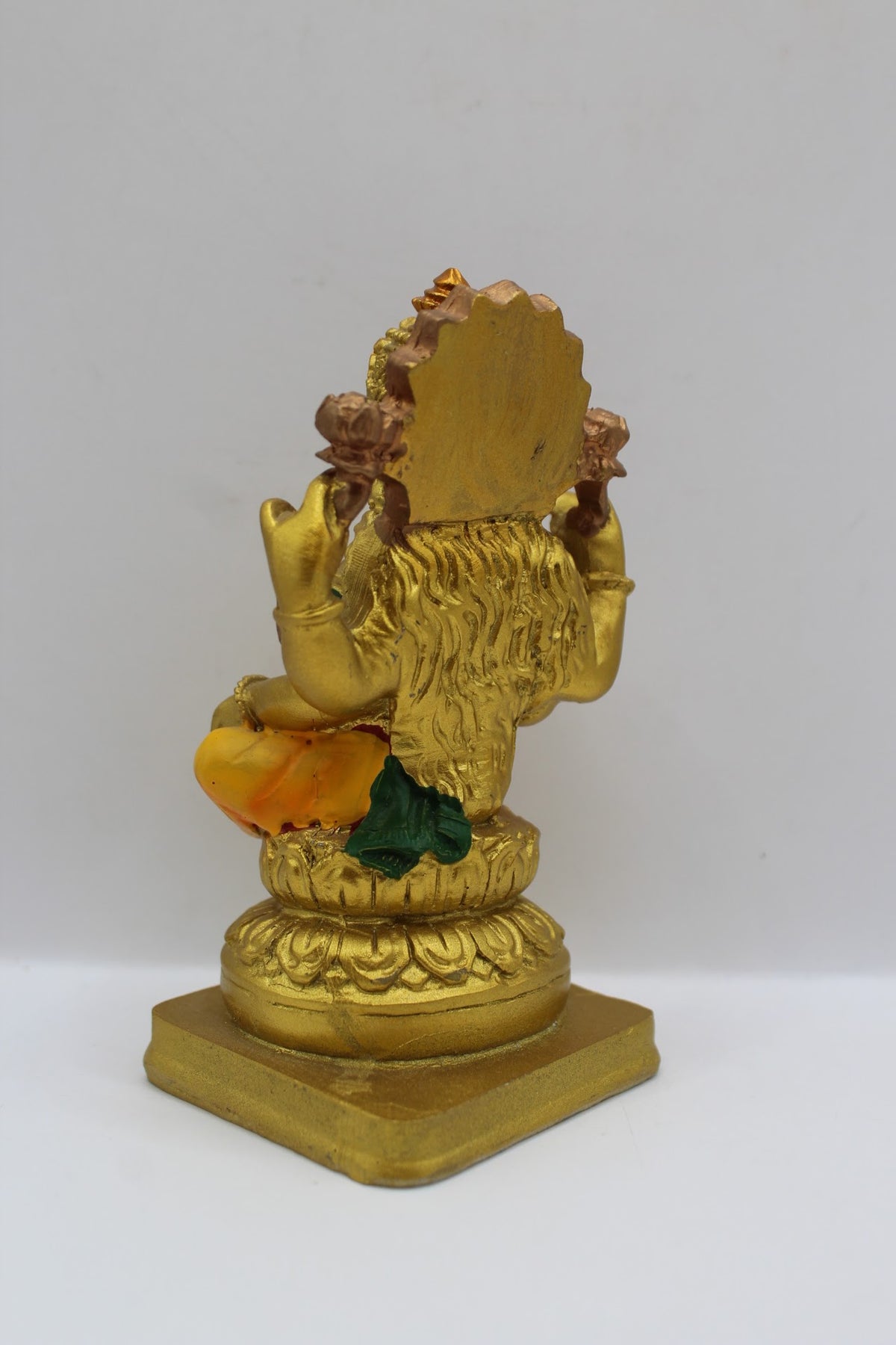 Small gold resin Laxmi murti with yellow clothes, back view
