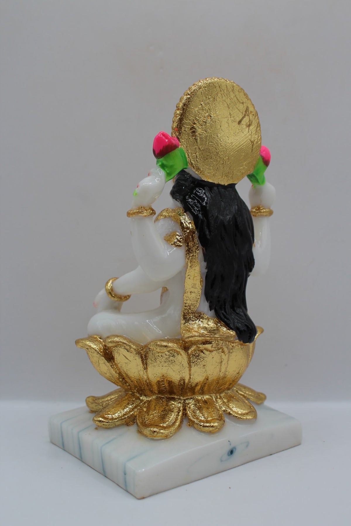 White and gold resin Laxmi murti on a gold lotus, back view