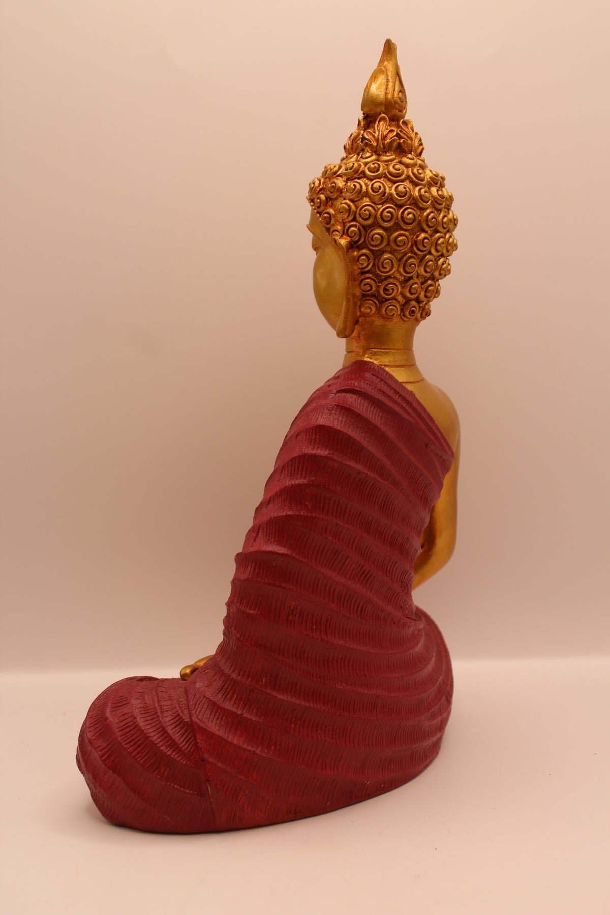 Maroon meditating Buddha statue, back