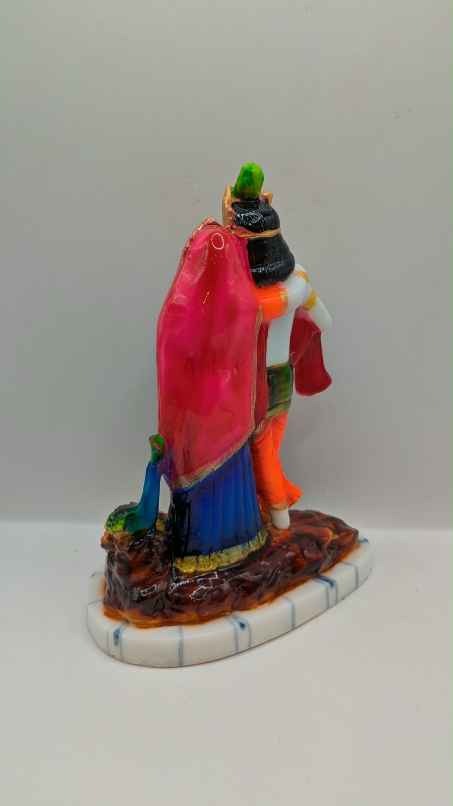 Colourful Radha Krishna statue with peacock, back view
