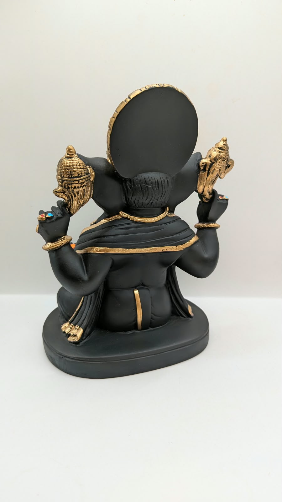 Black and gold Ganesh statue with big crown, back view
