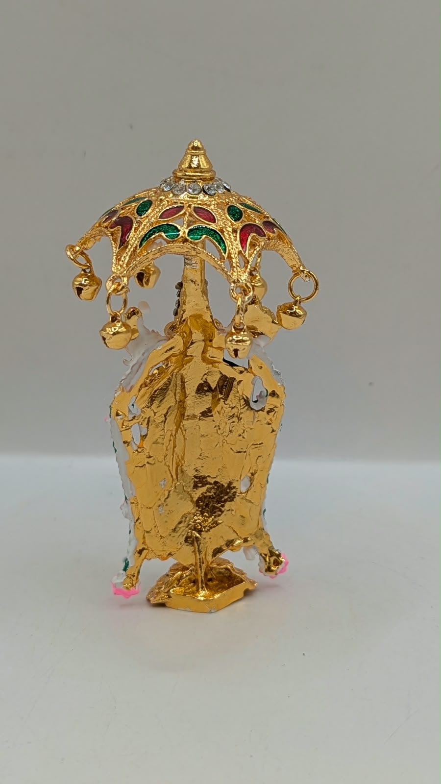Gold Tirupati Balaji murti under umbrella, back view