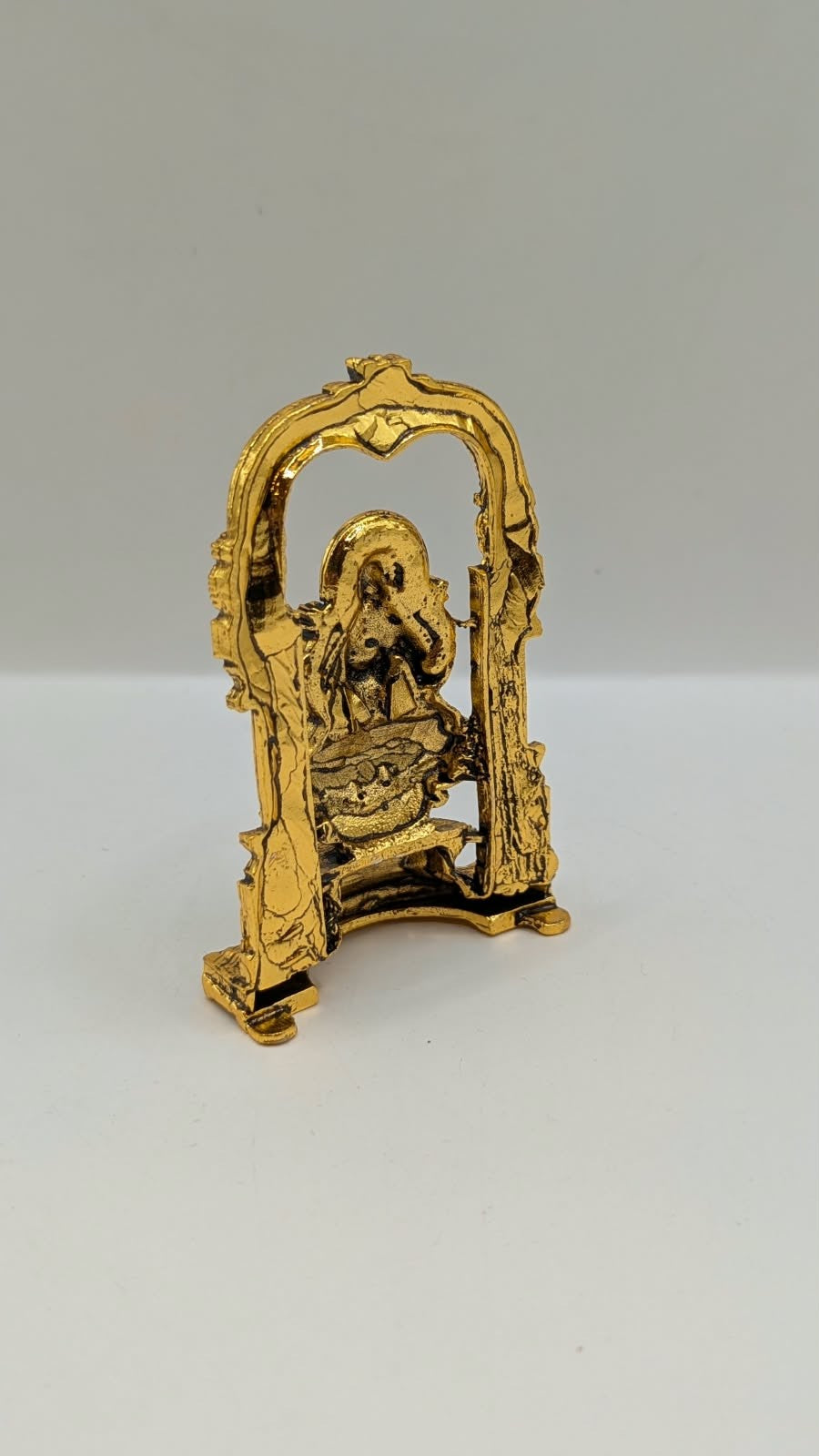 Antique gold Laxmi murti in temple arch, back view