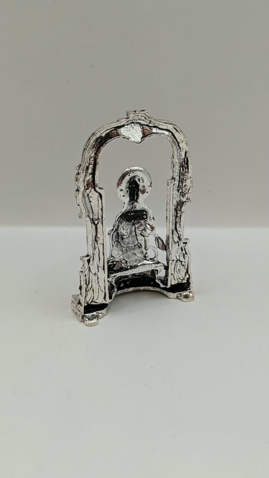Silver Hanuman murti in temple arch, back view
