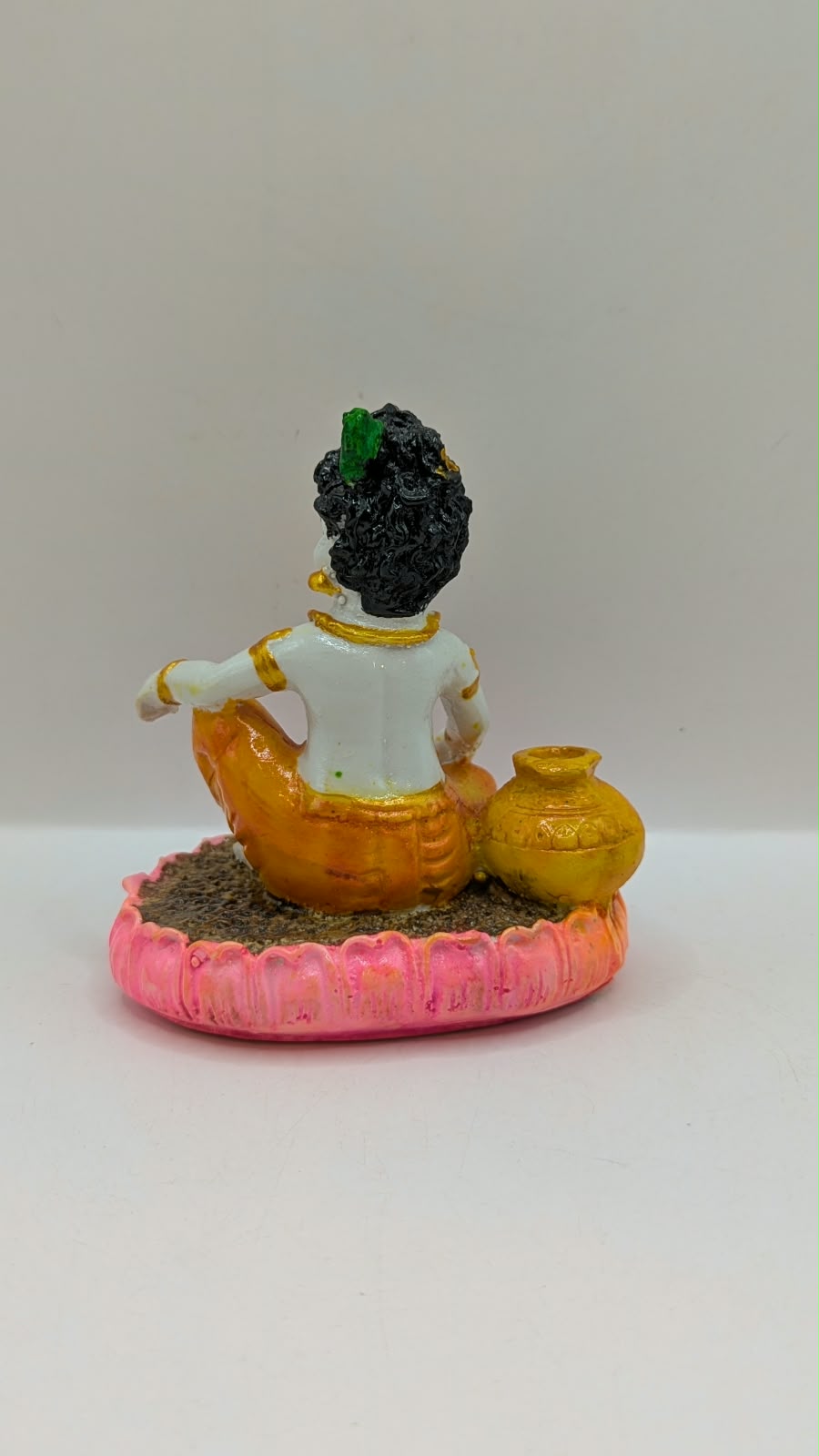 Baby Krishna statue on pink lotus, back view