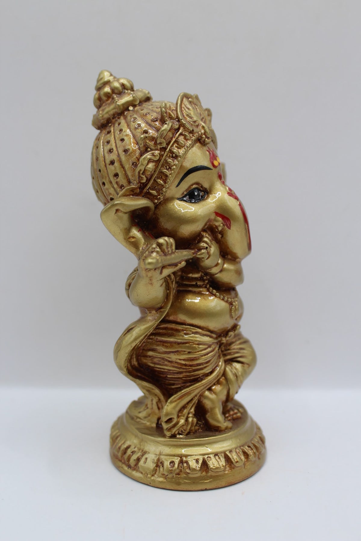 Gold resin Ganesh murti standing, playing flute, left side view