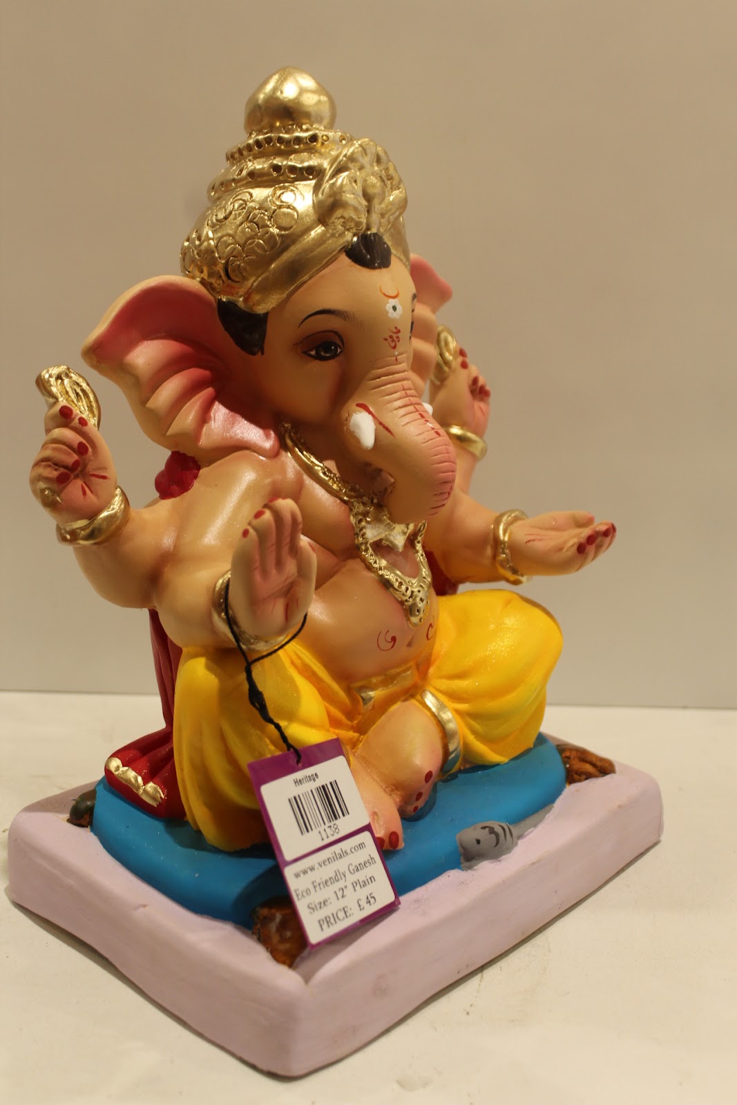 Eco-friendly clay Ganesh idol with red khes and yellow dhoti, side view