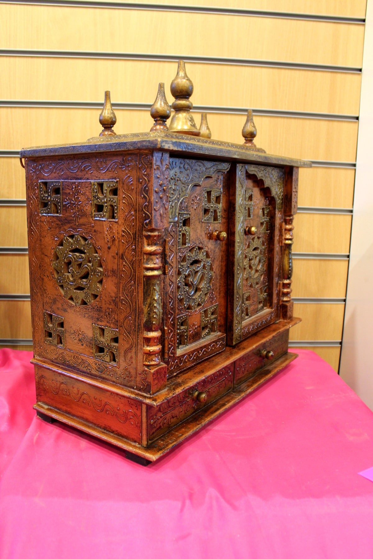 Antique wooden mandir with doors open showing carved arch niche