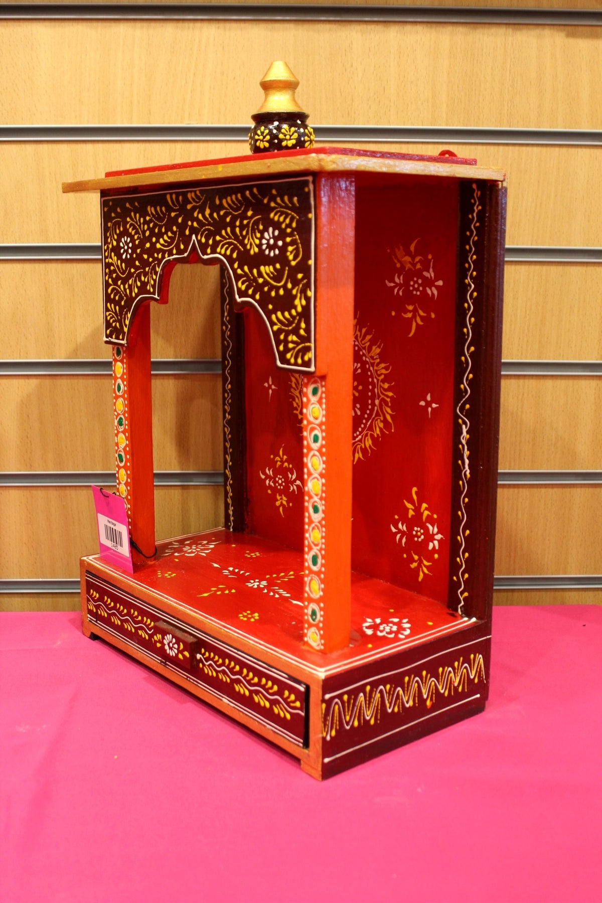 Close-up of gold floral scrollwork on the red arch and back panel