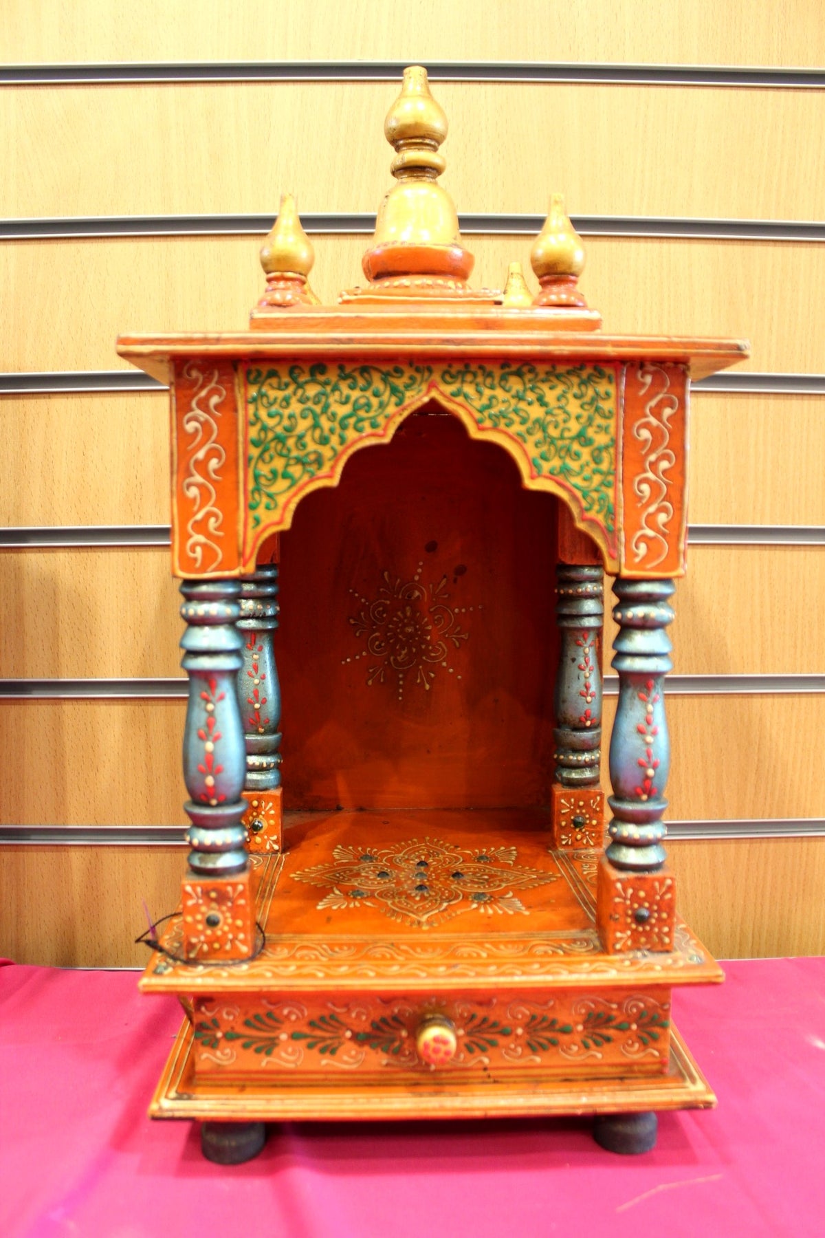 Orange hand-painted Jaipuri mandir with carved pillars, front view