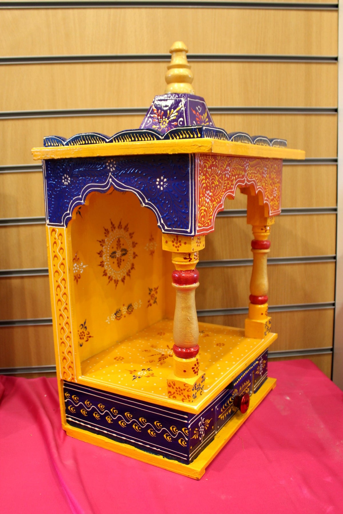 Marigold Jaipuri mandir seen from a side angle showing painted frame and depth