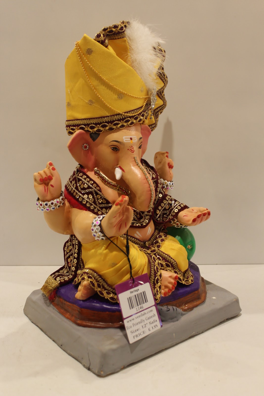 Eco-friendly clay Ganesh idol with yellow pheta and maroon embroidered robe, side view