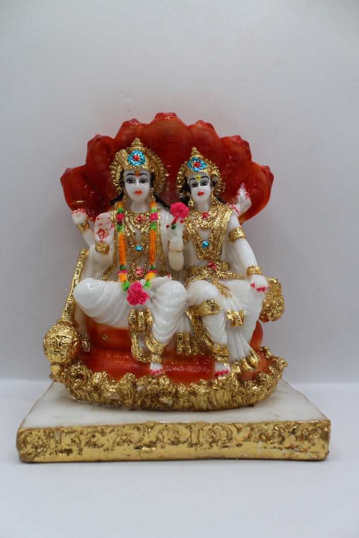 White and orange resin Vishnu Laxmi murti, seated under Sheshnaag, front view