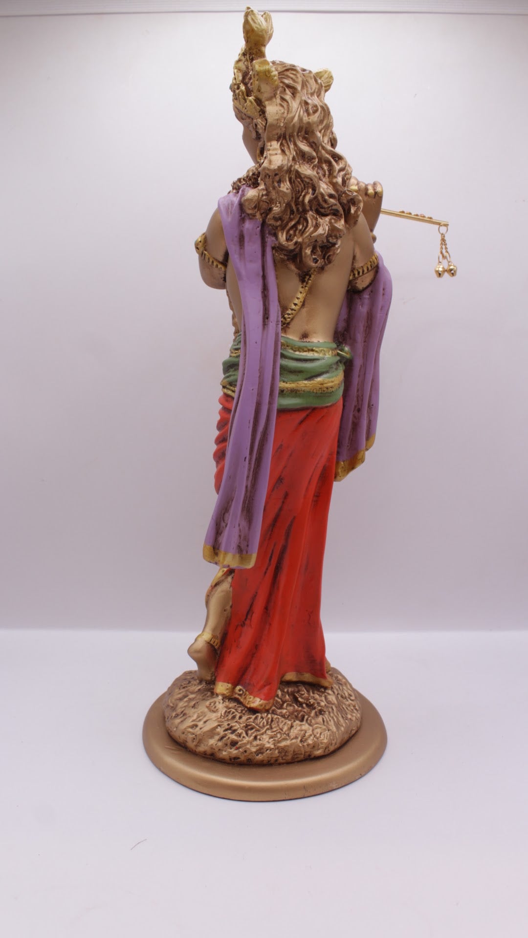 Painted resin Krishna statue playing flute, back view