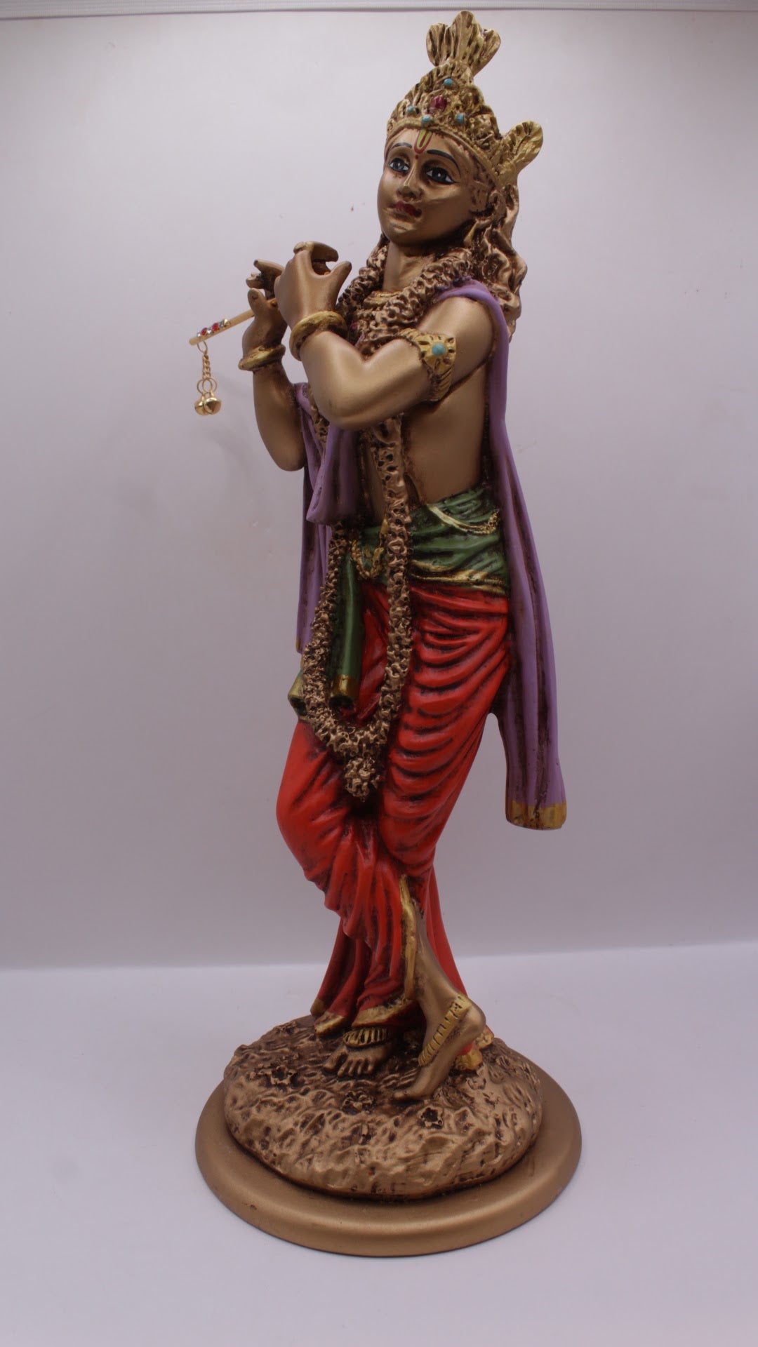 Painted resin Krishna statue playing flute, right side view