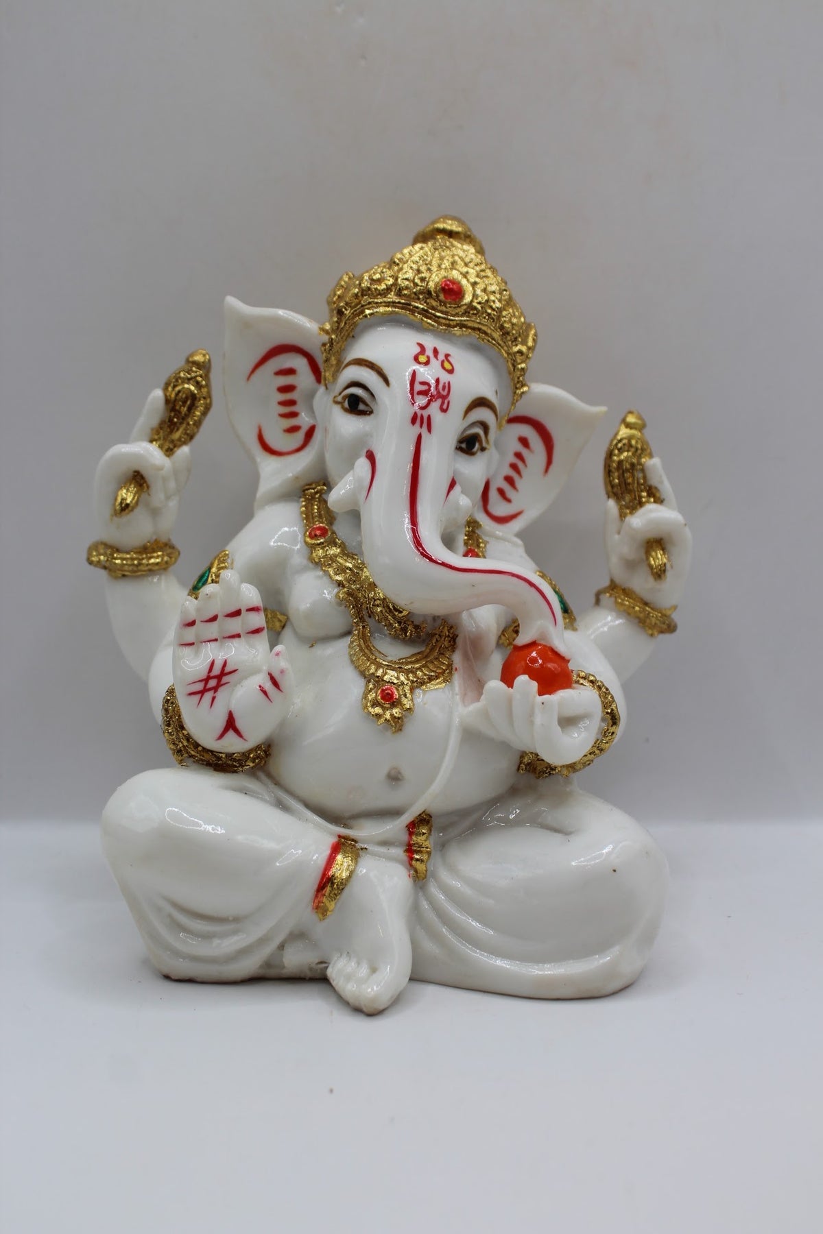 White and gold resin Ganesh murti seated, front view