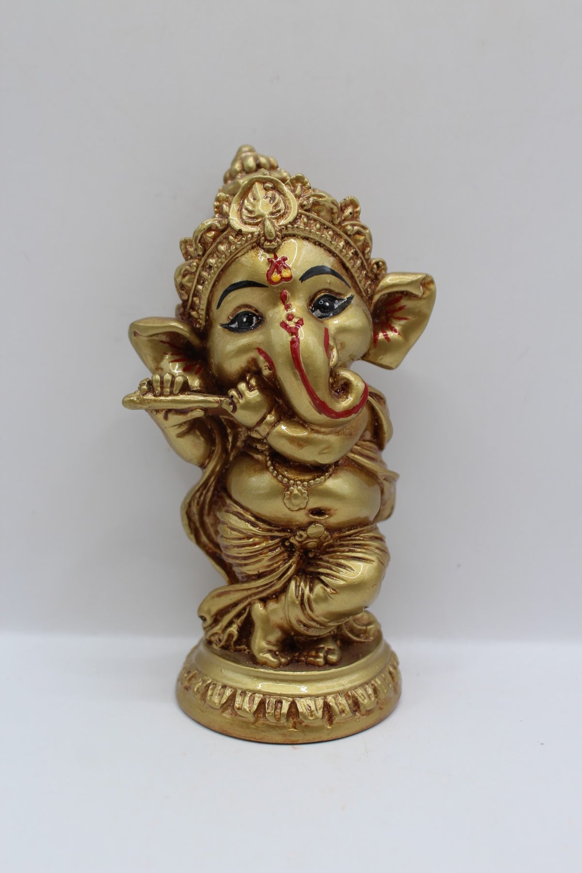Gold resin Ganesh murti standing, playing flute, front view