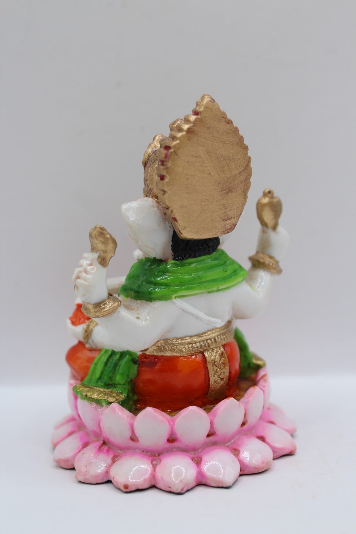 Resin Ganesh murti on pink lotus, orange dhoti, back view