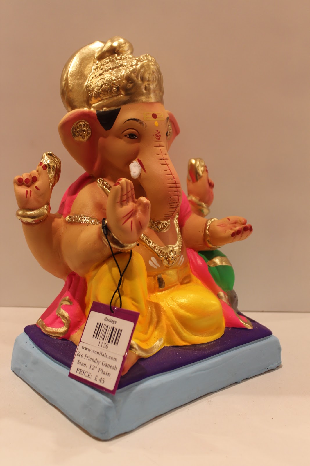 Eco-friendly clay Ganesh idol with pink khes and yellow dhoti, side view