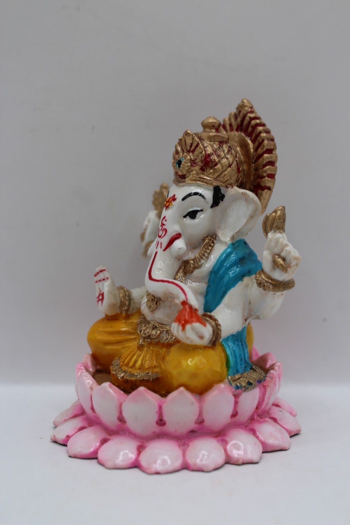 Resin Ganesh murti on pink lotus, yellow dhoti, right side view