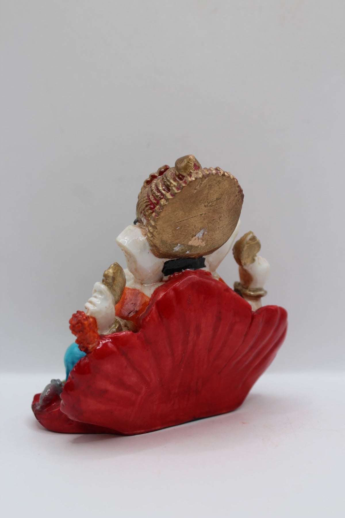 Resin Ganesh murti on red leaf, blue dhoti, back view