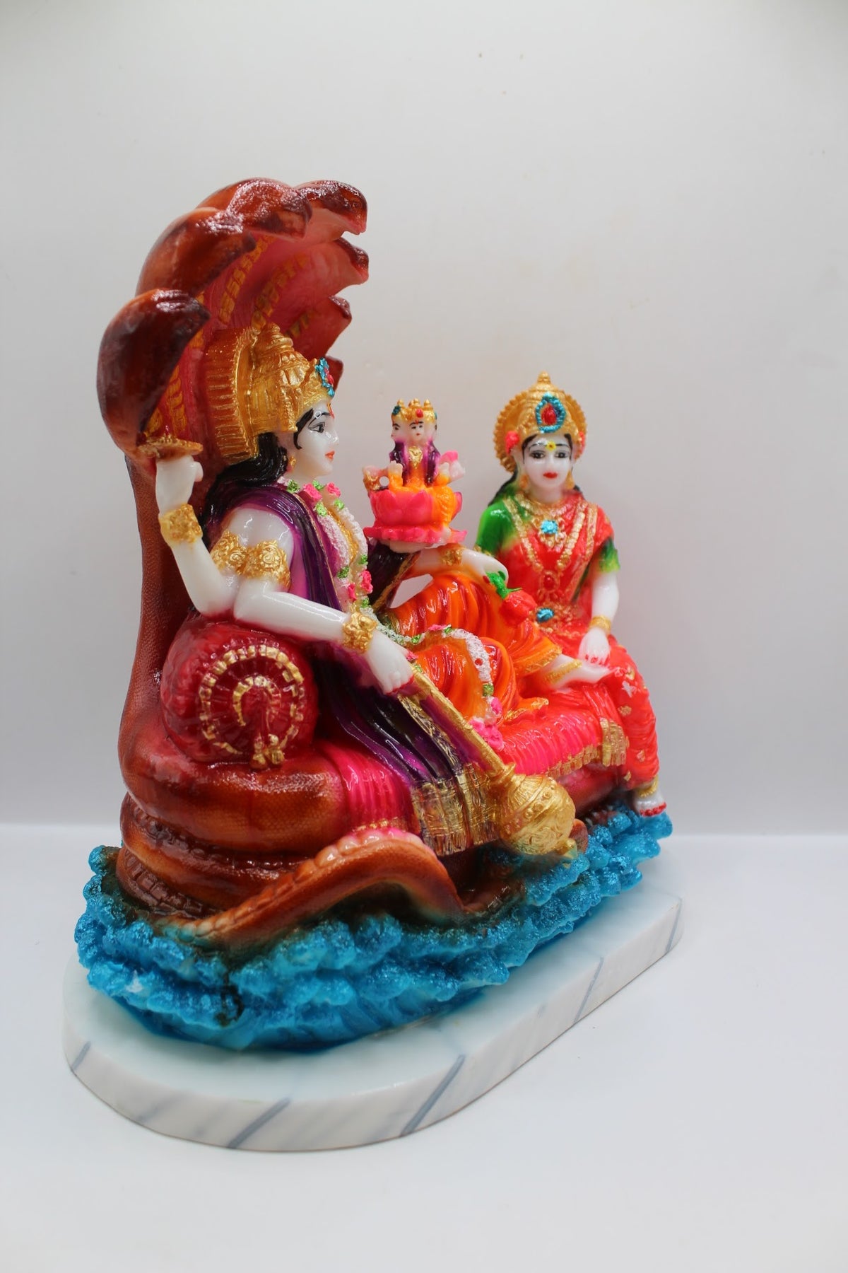 Colourful resin Vishnu Laxmi murti on Sheshnaag, left side view