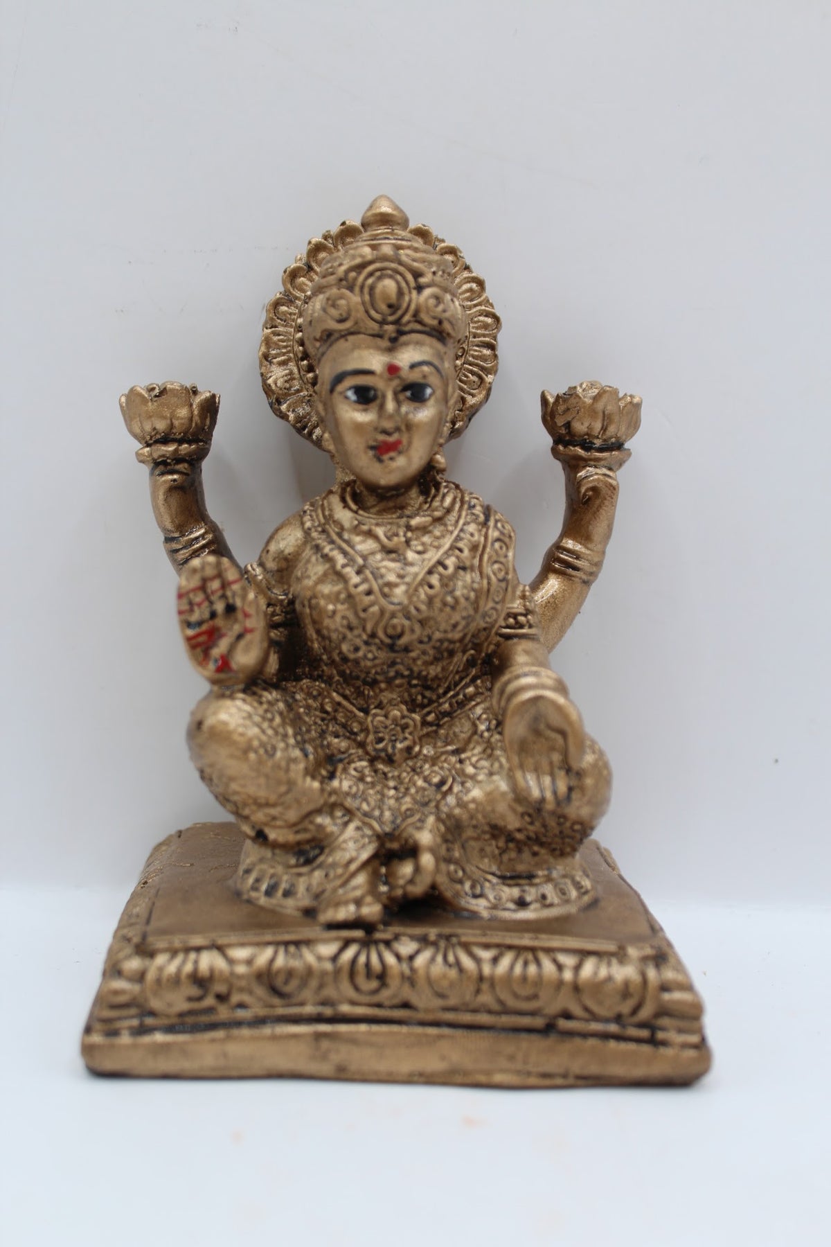 Antique gold resin Laxmi murti seated on square base, front view