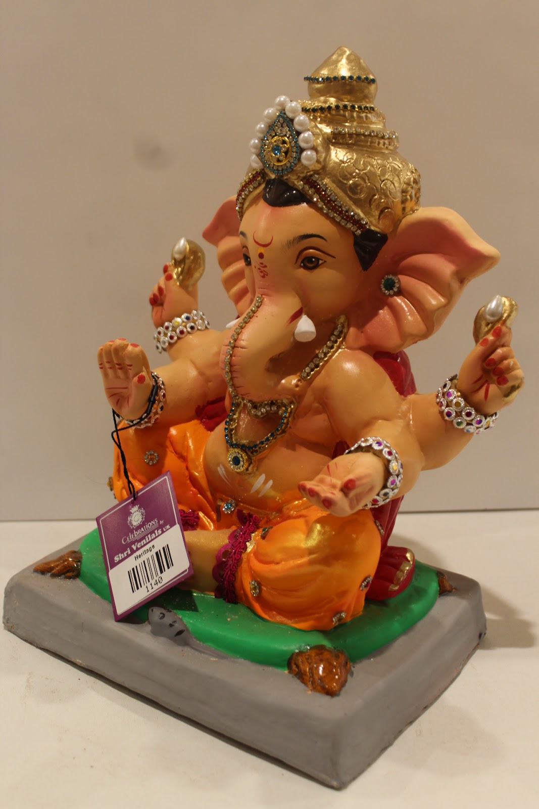 Eco-friendly clay Ganesh idol in jewellery style with pearl and teal crown, side view