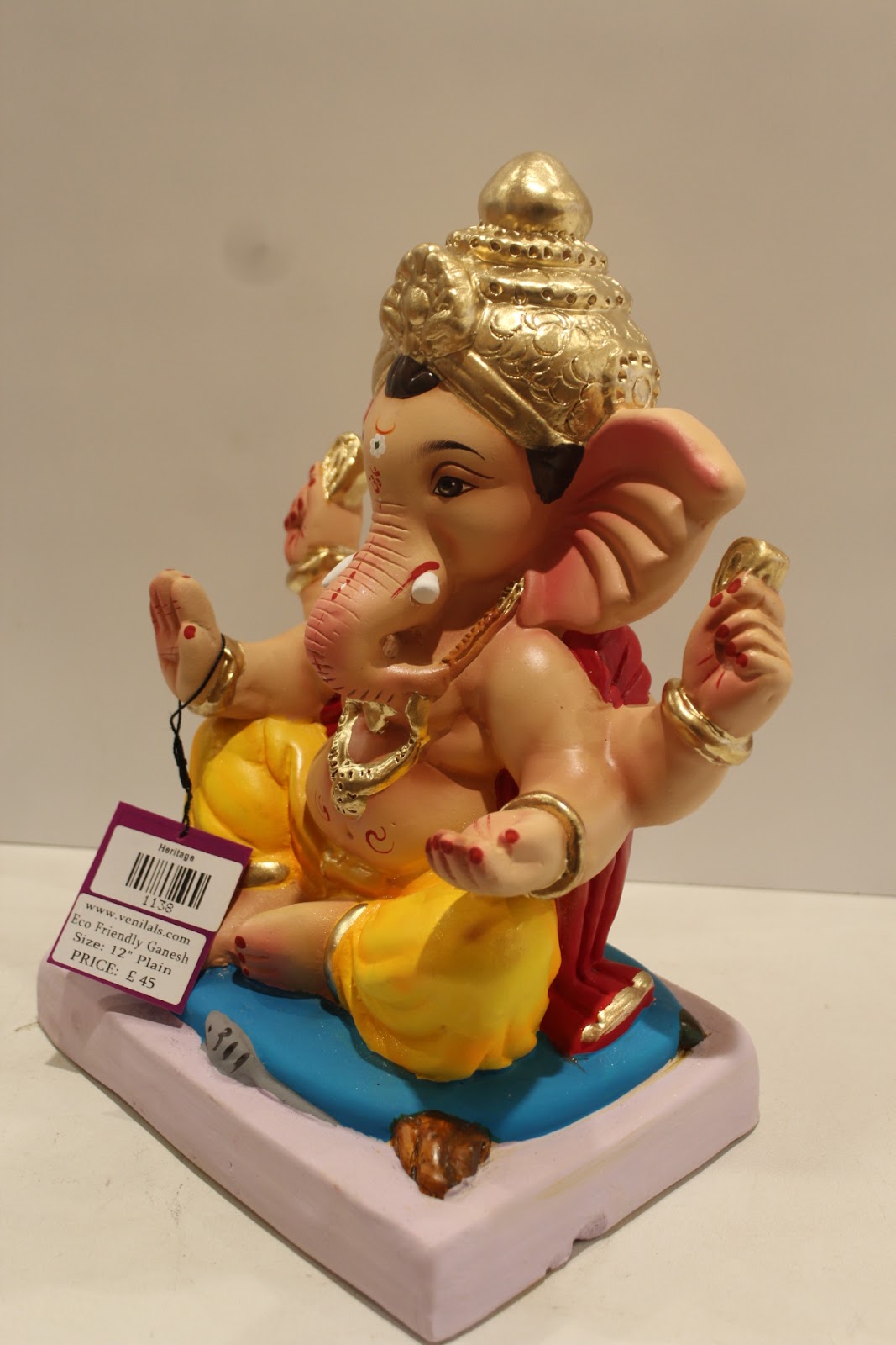Eco-friendly clay Ganesh idol with red khes and yellow dhoti, side view
