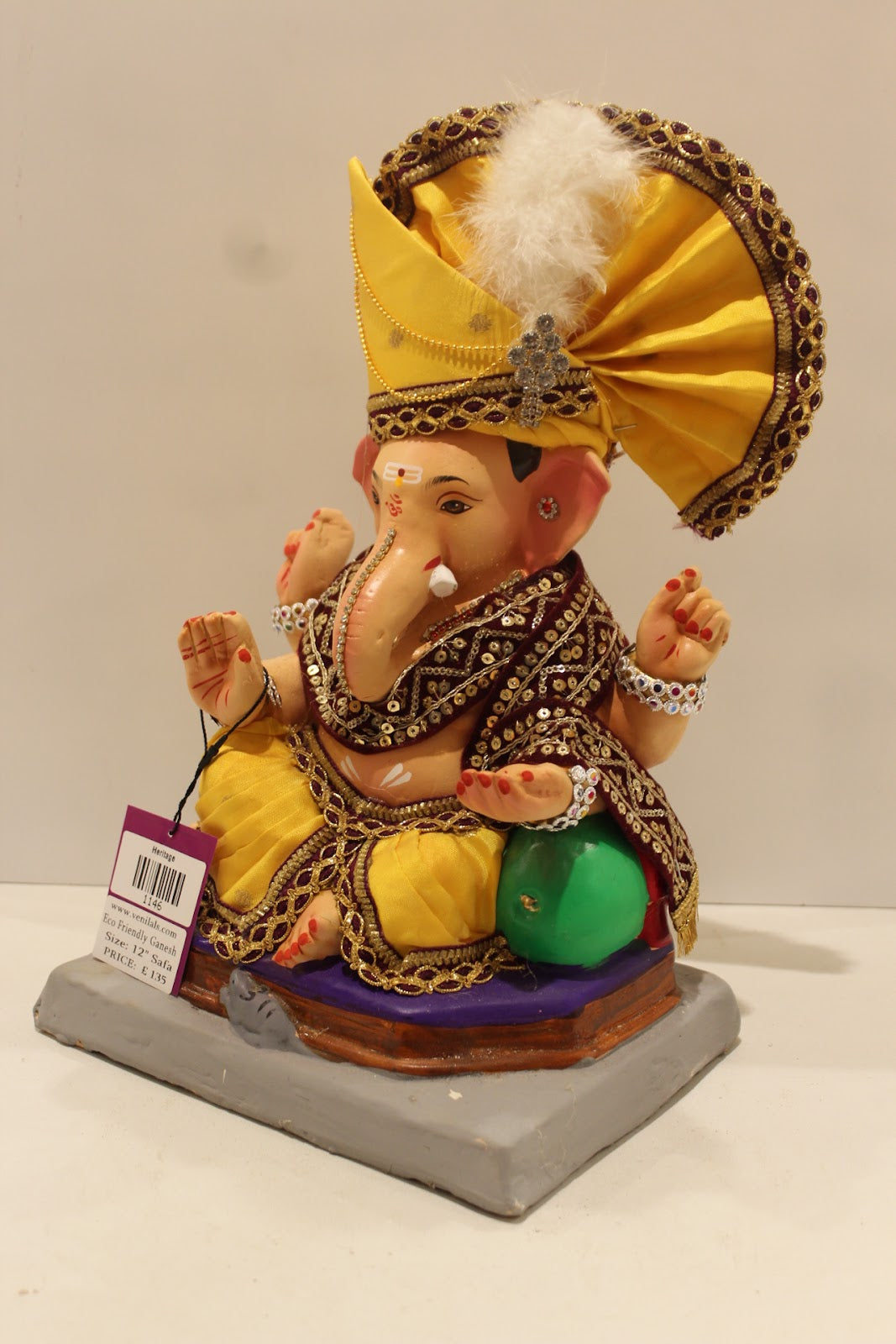 Eco-friendly clay Ganesh idol with yellow pheta and maroon embroidered robe, side view