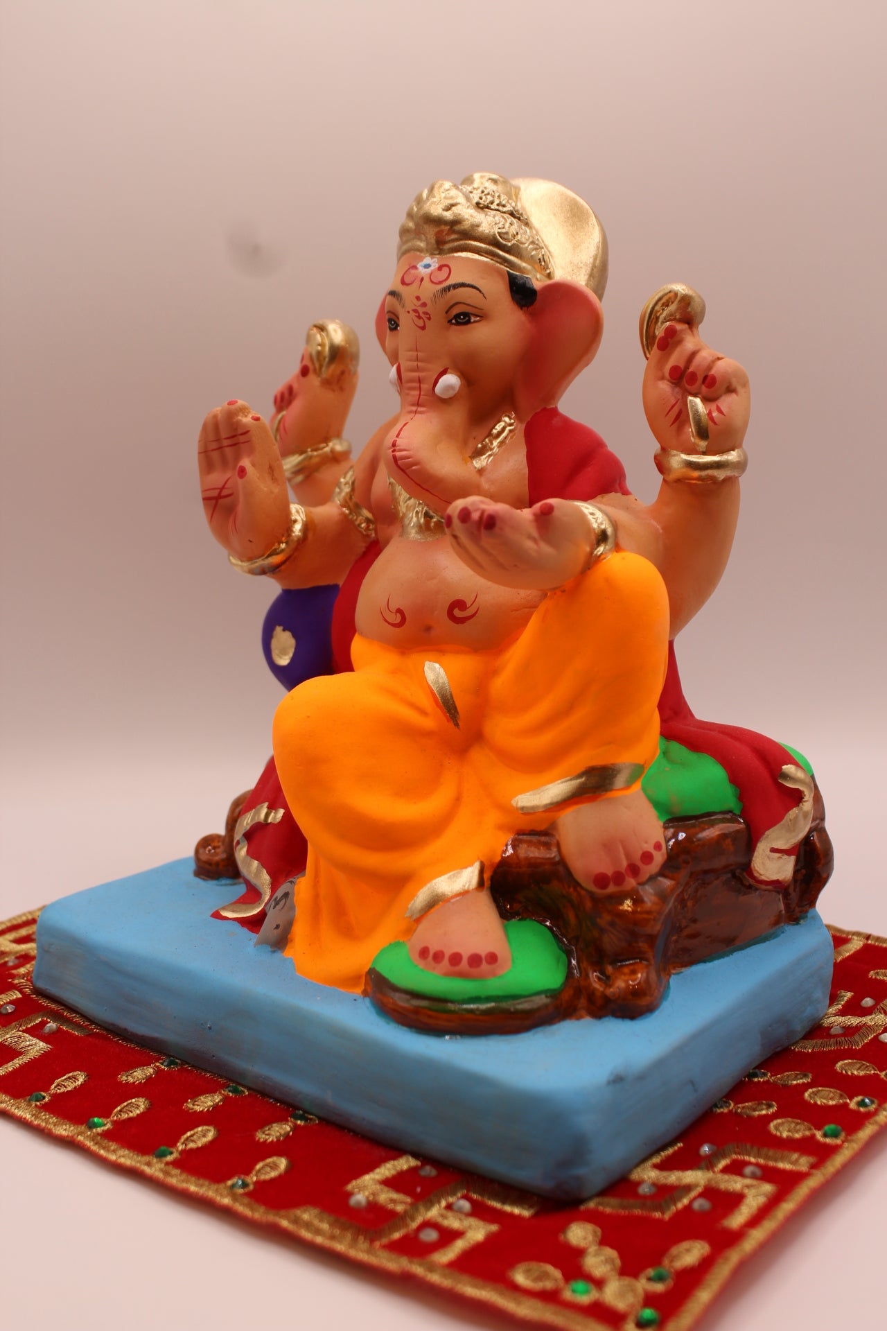 Eco-friendly 8 inch Ganesh Visarjan idol in maroon shawl and orange dhoti – detail view