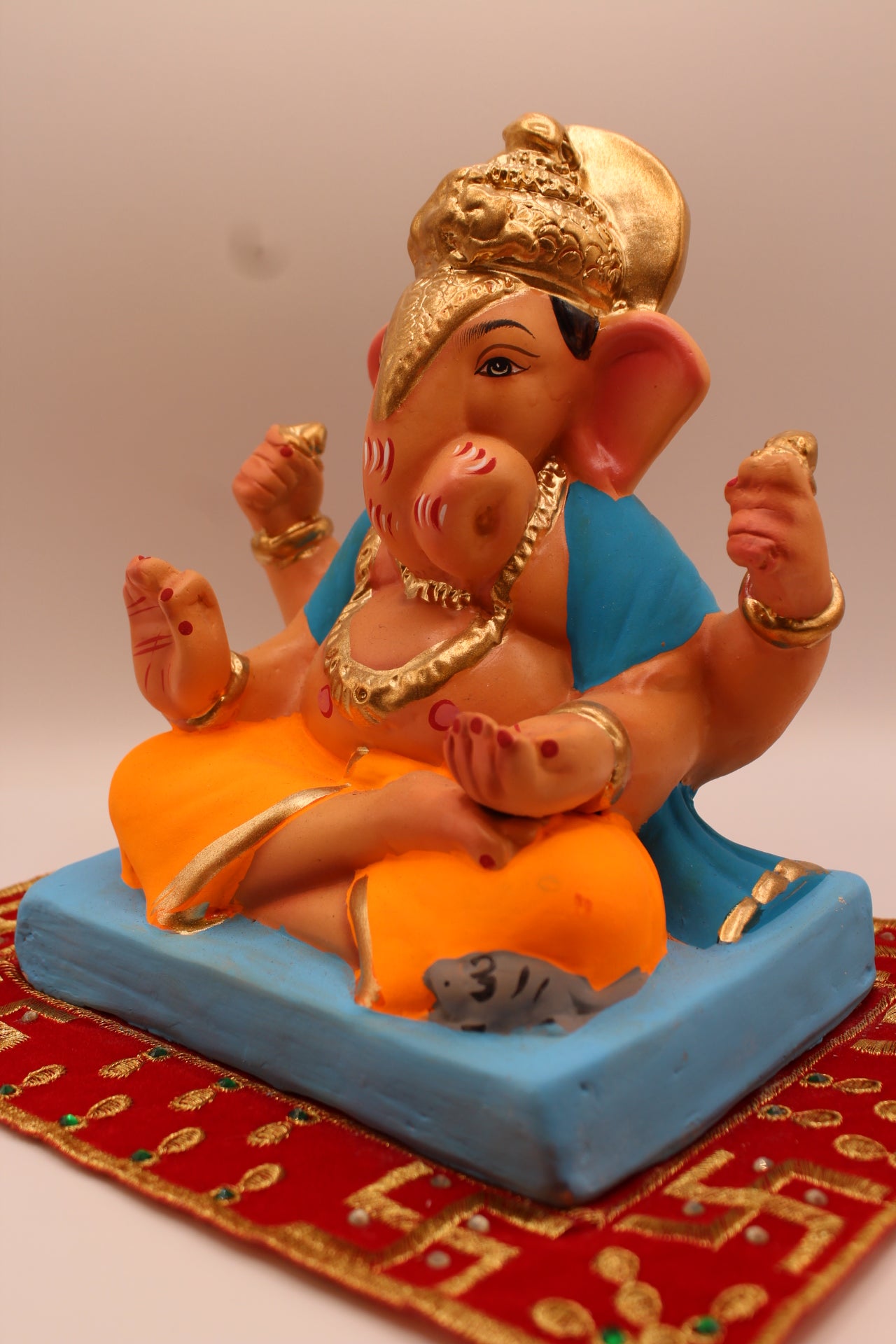 Eco-friendly 8 inch Ganesh Visarjan idol in sky blue shawl and orange dhoti – detail view