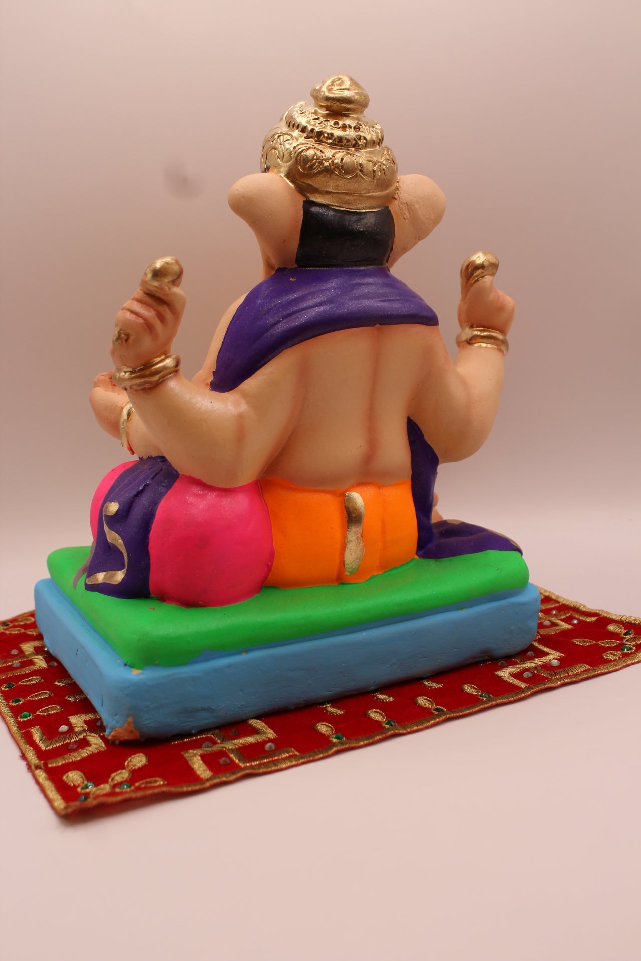 Eco-friendly 8 inch Ganesh Visarjan idol in purple shawl and orange dhoti – back view