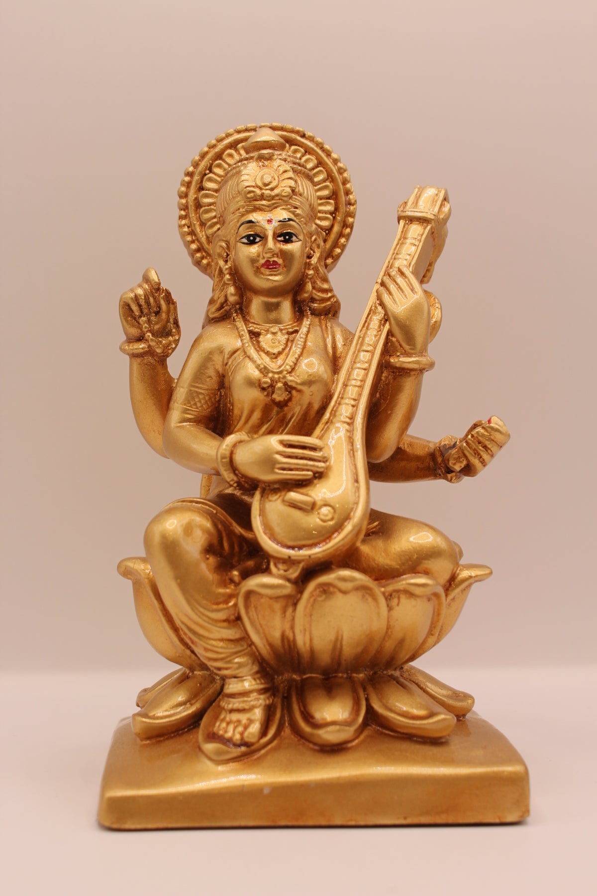 Gold Saraswati resin statue with veena, front