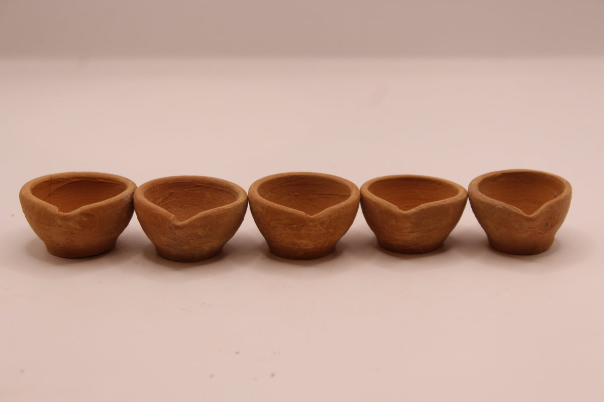 Five plain clay diyas in a row
