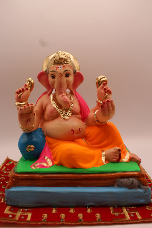 Eco-friendly 8 inch Ganesh Visarjan idol in pink khes and orange dhoti, relaxed pose – front view