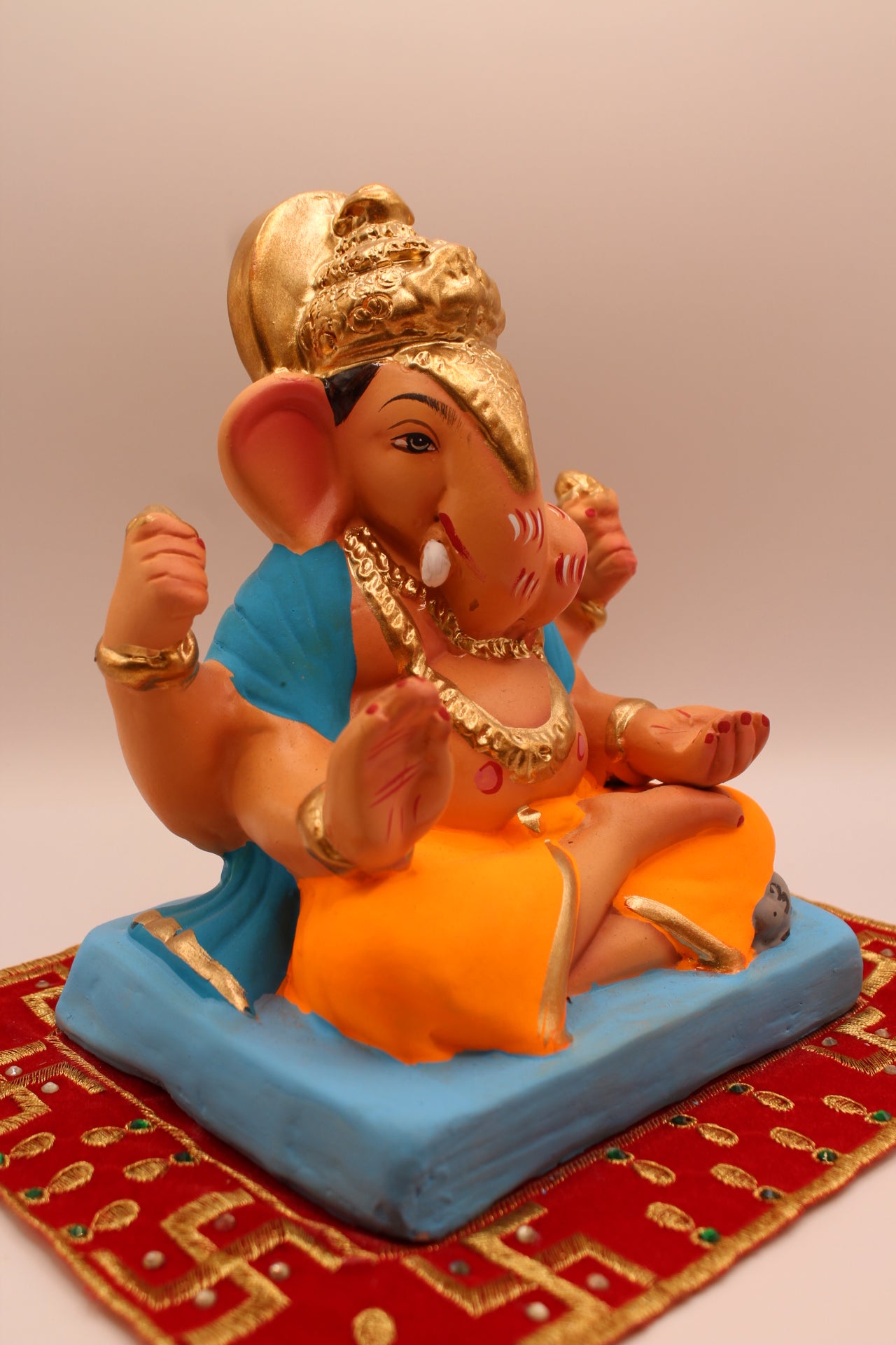 Eco-friendly 8 inch Ganesh Visarjan idol in sky blue shawl and orange dhoti – side view