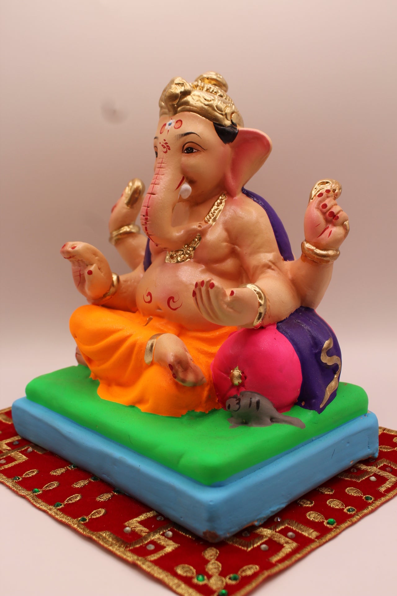 Eco-friendly 8 inch Ganesh Visarjan idol in purple shawl and orange dhoti – detail view