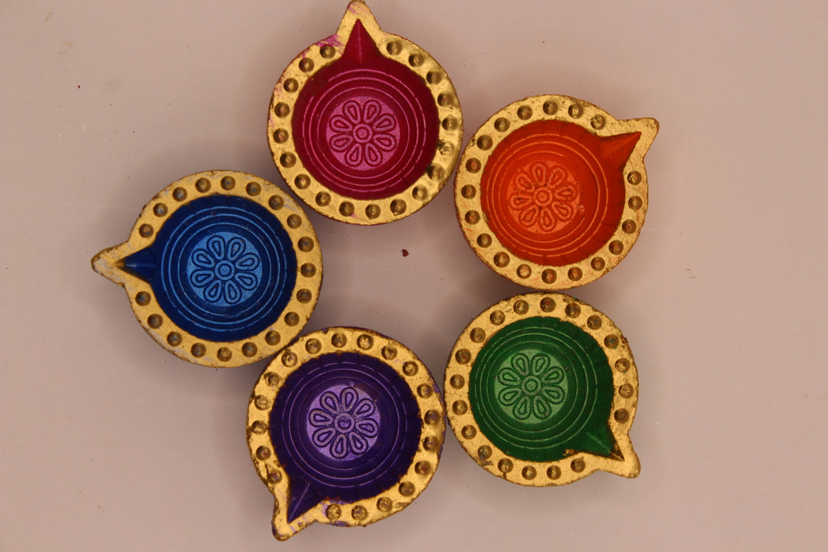 Five painted clay diyas from above