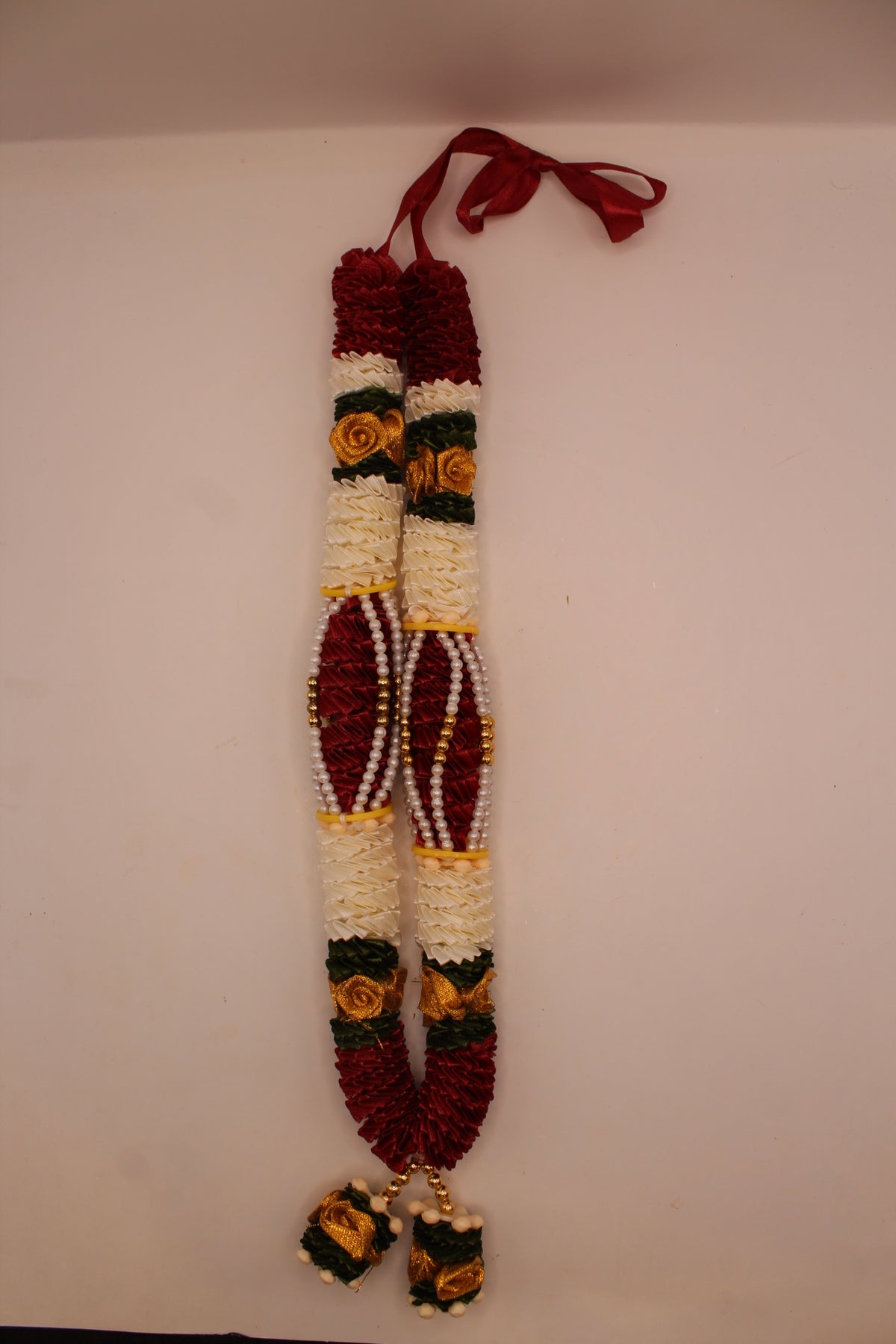 Maroon and white garland mala laid flat