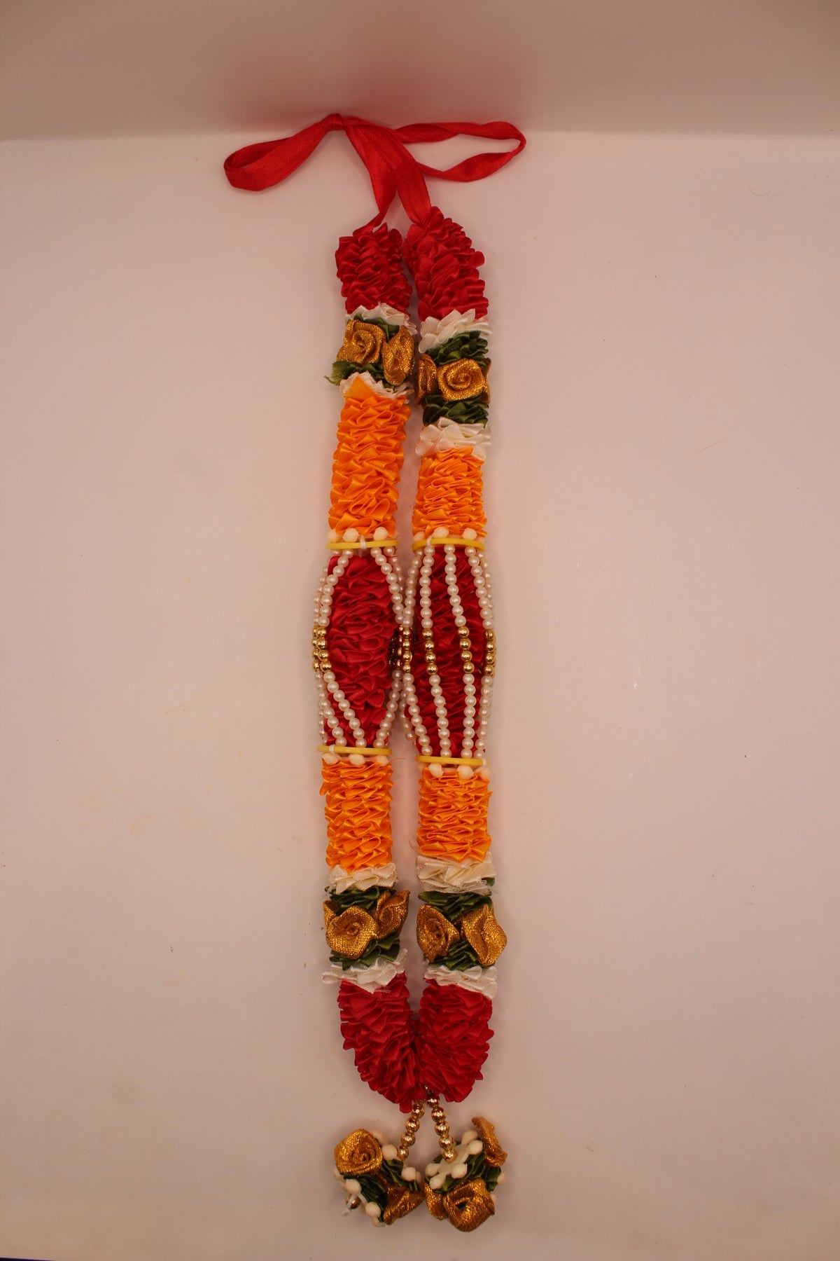 Orange and red garland mala laid flat