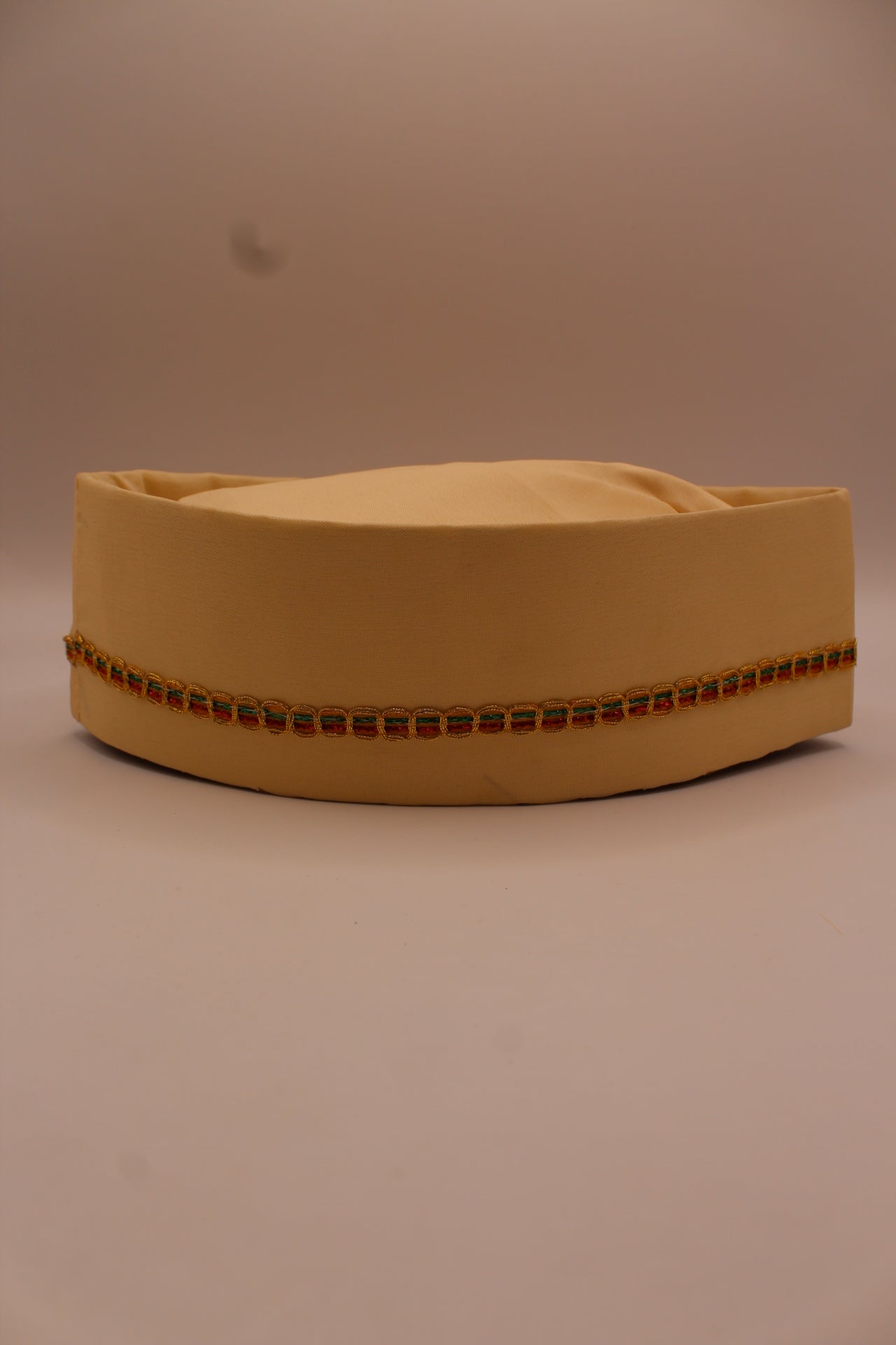 Cream Gandhi topi with gold braid trim, front view