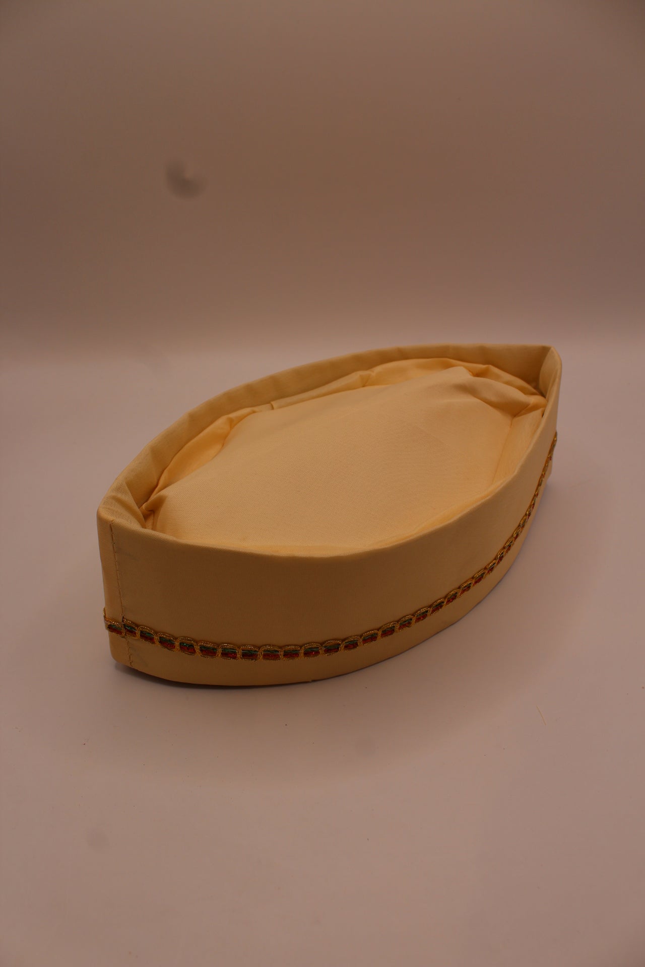 Cream Gandhi topi with gold braid trim, side view